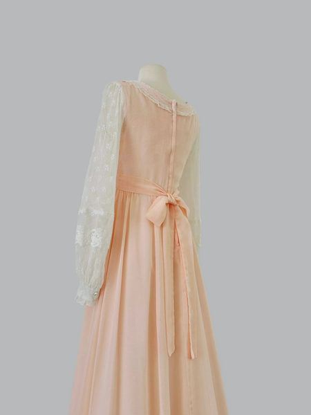 1970s Gunne Sax pastel peach maxi gown with lace-up bodice, pearl beading, high waist, and sheer lace sleeves