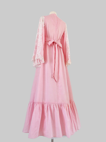 1970s pink gingham prairie-style maxi dress featuring lace angel sleeves.