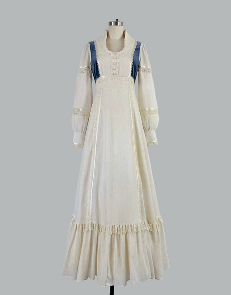 Vintage 1970s Gunne Sax prairie maxi dress featuring natural cream cotton fabric with blue velvet accents, embodying classic bohemian style with a flowing silhouette and nostalgic charm.