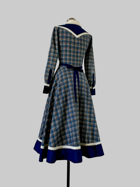 Back View of Vintage 1970s Gunne Sax blue plaid Western-style dress with button-front bodice, cream placket, navy yoke, ric-rac trim, curved pockets, and full skirt