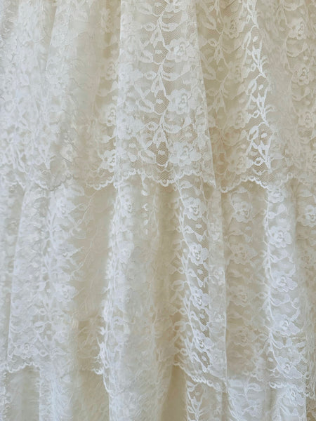 Close-up of a white lace fabric with intricate patterns.