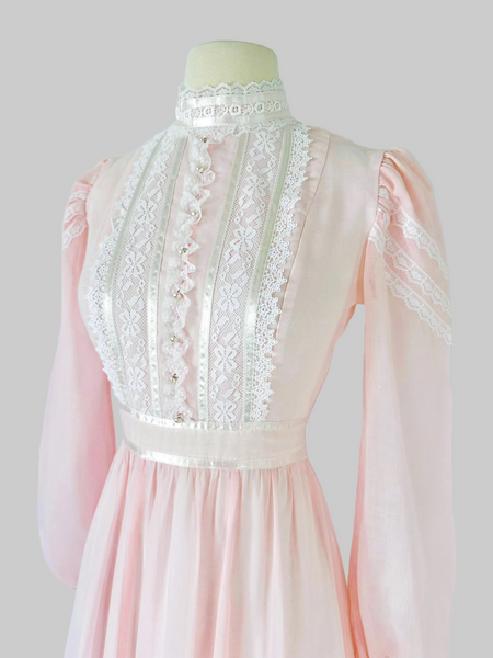 Vintage 1970s Gunne Sax blush pink gown with lace bodice, high Victorian neckline, pearl buttons, and flowing semi-sheer skirt with waist tie