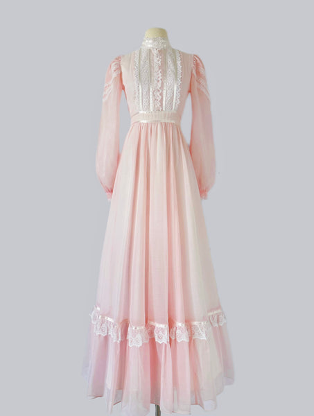 Vintage 1970s Gunne Sax blush pink gown with lace bodice, high Victorian neckline, pearl buttons, and flowing semi-sheer skirt with waist tie