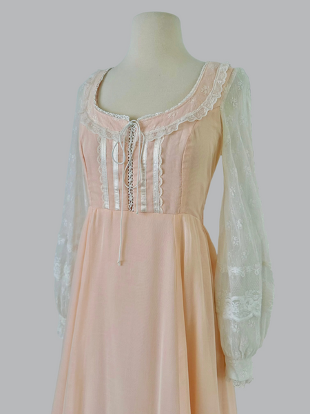 1970s Gunne Sax pastel peach maxi gown with lace-up bodice, pearl beading, high waist, and sheer lace sleeves