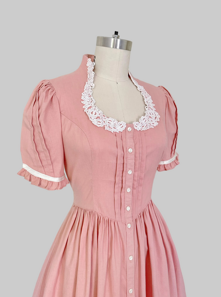 Vintage 1970s Gunne Sax midi dress in rose pink with puffed sleeves, lace trim, and front button closures