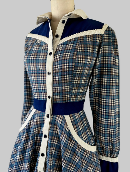 Vintage Gunne Sax blue plaid Western-style dress with button-front bodice, cream placket, navy yoke, ric-rac trim, curved pockets, and full skirt