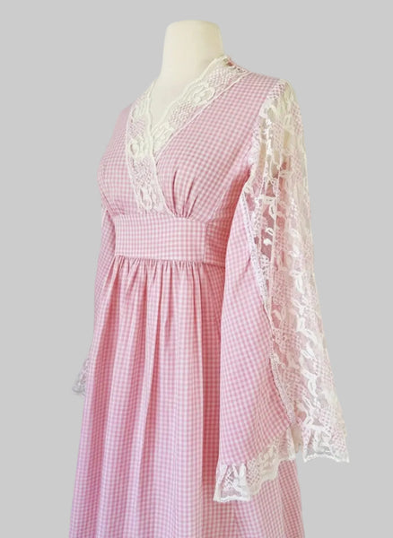 1970s pink gingham prairie-style maxi dress featuring lace angel sleeves.