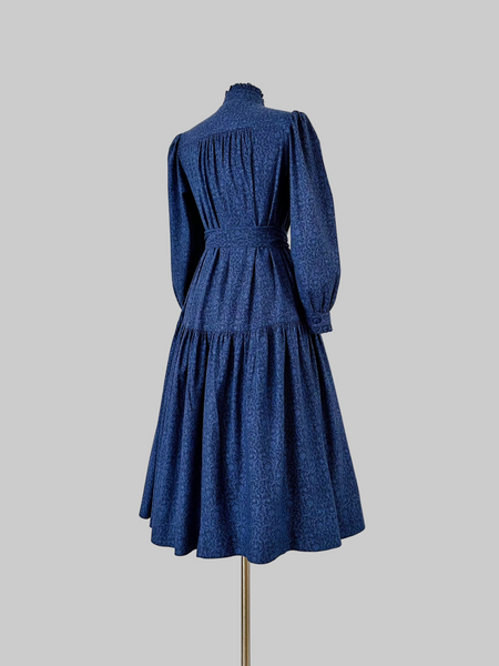 Vintage 1980s Laura Ashley blue paisley cotton dress with ruffled high neck, puffed sleeves, fabric-covered buttons, and removable waist sash