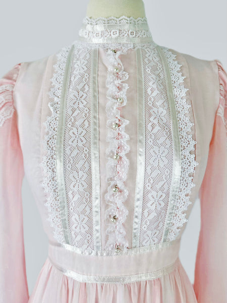 Vintage 1970s Gunne Sax blush pink gown with lace bodice, high Victorian neckline, pearl buttons, and flowing semi-sheer skirt with waist tie
