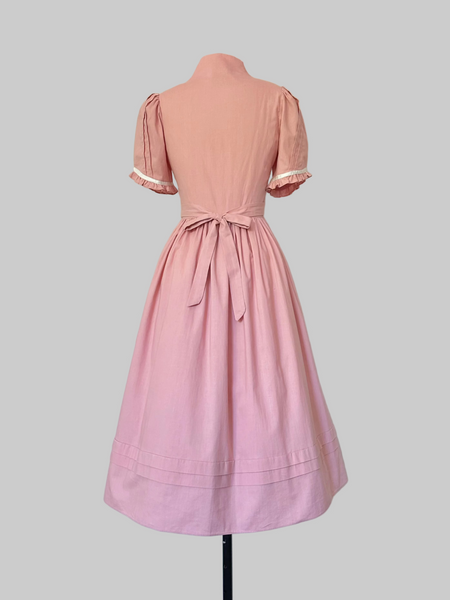 Vintage 1970s Gunne Sax midi dress in rose pink with puffed sleeves, lace trim, and front button closures