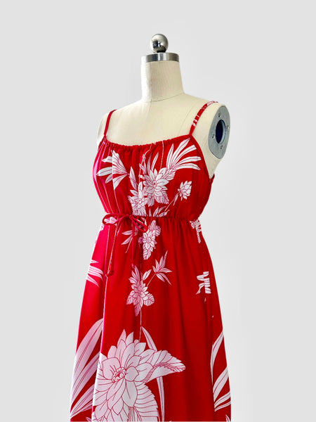 Vintage 1970s / 1980s red dress with large white tropical floral print, spaghetti straps, and an elasticized empire waist with tie detail; maxi length with soft, flowing drape