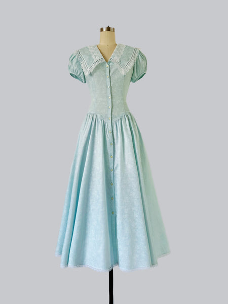 Vintage 1980s Gunne Sax dress in soft ice blue with tonal floral print, oversized lace-trimmed sailor collar, fitted waist, and full skirt.