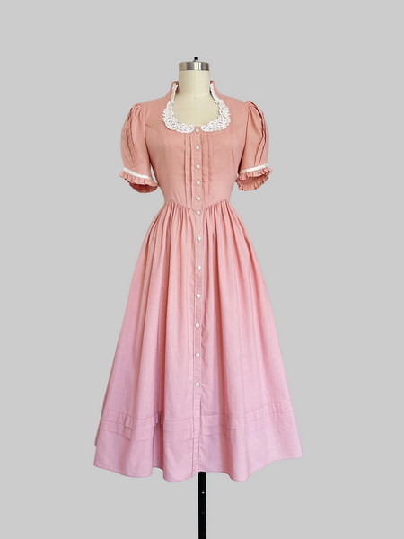 Vintage 1970s Gunne Sax midi dress in rose pink with puffed sleeves, lace trim, and front button closures