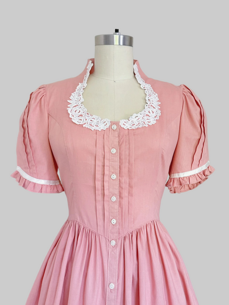 Vintage 1970s Gunne Sax midi dress in rose pink with puffed sleeves, lace trim, and front button closures