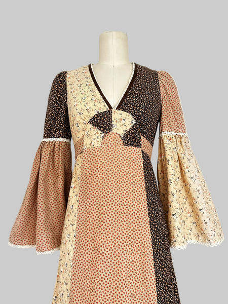 1970s Trivia by Charm of Hollywood patchwork maxi dress in chocolate brown, beige, and butter yellow with mixed ditsy floral prints, long bell sleeves, and ruffled hem.