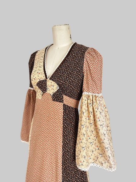 1970s Trivia by Charm of Hollywood patchwork maxi dress in chocolate brown, beige, and butter yellow with mixed ditsy floral prints, long bell sleeves, and ruffled hem.