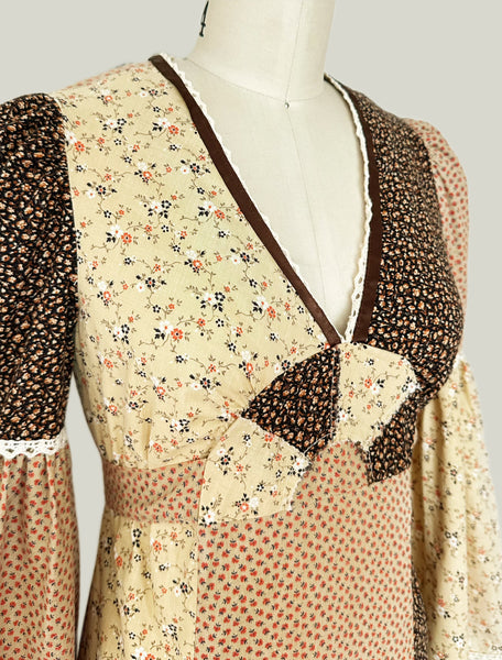 1970s Trivia by Charm of Hollywood patchwork maxi dress in chocolate brown, beige, and butter yellow with mixed ditsy floral prints, long bell sleeves, and ruffled hem.
