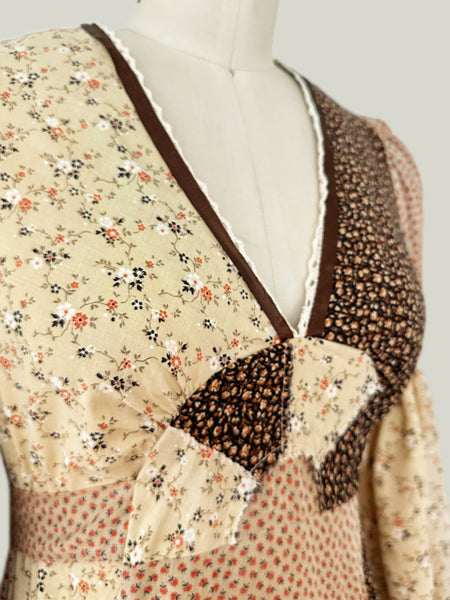 1970s Trivia by Charm of Hollywood patchwork maxi dress in chocolate brown, beige, and butter yellow with mixed ditsy floral prints, long bell sleeves, and ruffled hem.