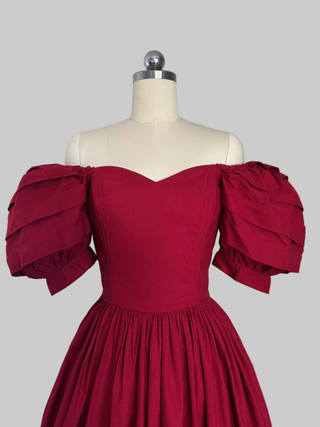 1980s Laura Ashley red cotton dress with a fitted boned sweetheart bodice, tiered puff sleeves, and full sweeping skirt