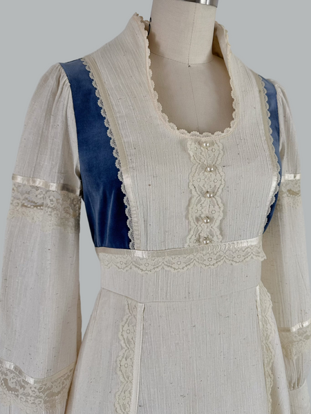 Vintage 1970s Gunne Sax prairie maxi dress featuring natural cream cotton fabric with blue velvet accents, embodying classic bohemian style with a flowing silhouette and nostalgic charm.