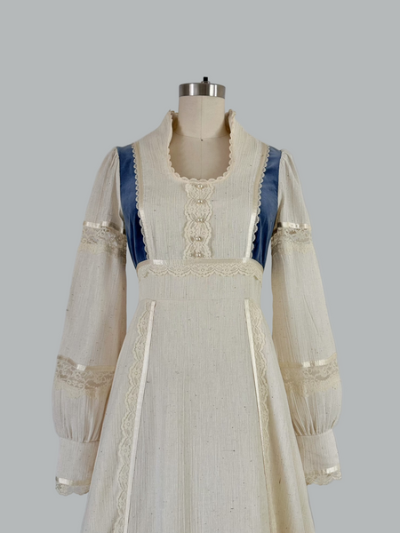 Vintage 1970s Gunne Sax prairie maxi dress featuring natural cream cotton fabric with blue velvet accents, embodying classic bohemian style with a flowing silhouette and nostalgic charm.