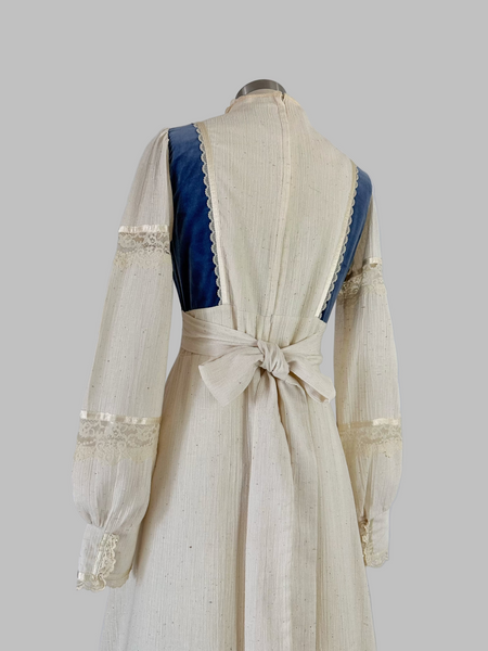 Vintage 1970s Gunne Sax prairie maxi dress featuring natural cream cotton fabric with blue velvet accents, embodying classic bohemian style with a flowing silhouette and nostalgic charm.