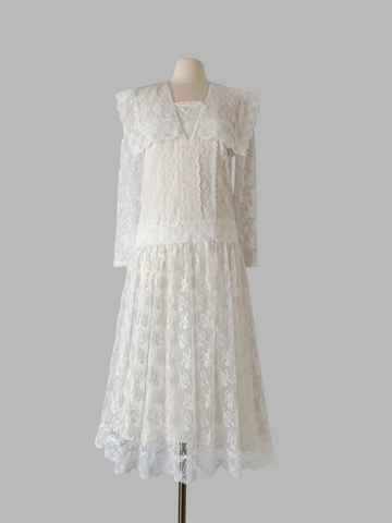 1980s Gunne Sax white lace dress with a drop-waist sailor collar, scalloped floral lace, sheer sleeves, and a light ankle-length skirt over a smooth satin lining