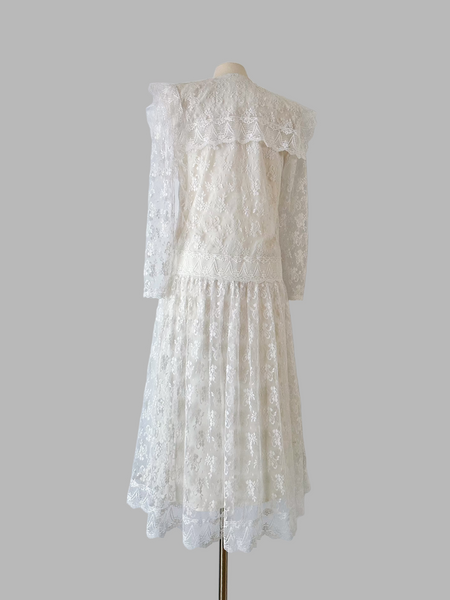 1980s Gunne Sax white lace dress with a drop-waist sailor collar, scalloped floral lace, sheer sleeves, and a light ankle-length skirt over a smooth satin lining