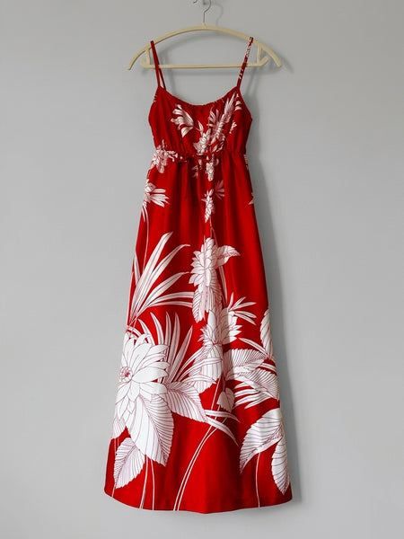 Vintage 1970s / 1980s red dress with large white tropical floral print, spaghetti straps, and an elasticized empire waist with tie detail; maxi length with soft, flowing drape