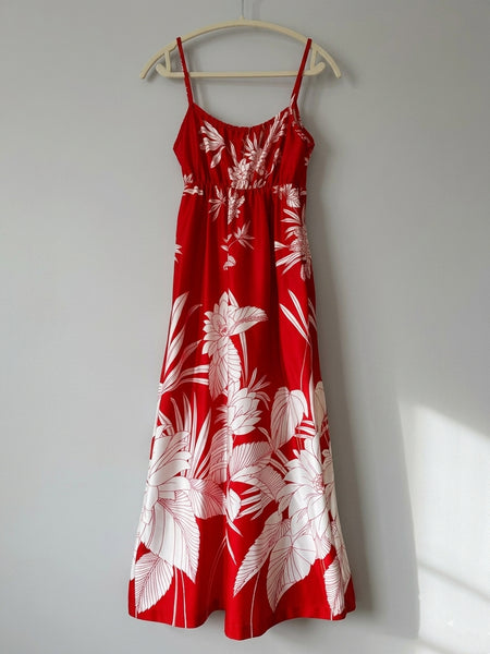 Vintage 1970s / 1980s red dress with large white tropical floral print, spaghetti straps, and an elasticized empire waist with tie detail; maxi length with soft, flowing drape